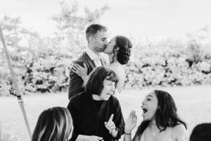 A black and white candid moment of celebration and laughter at a wedding reception.