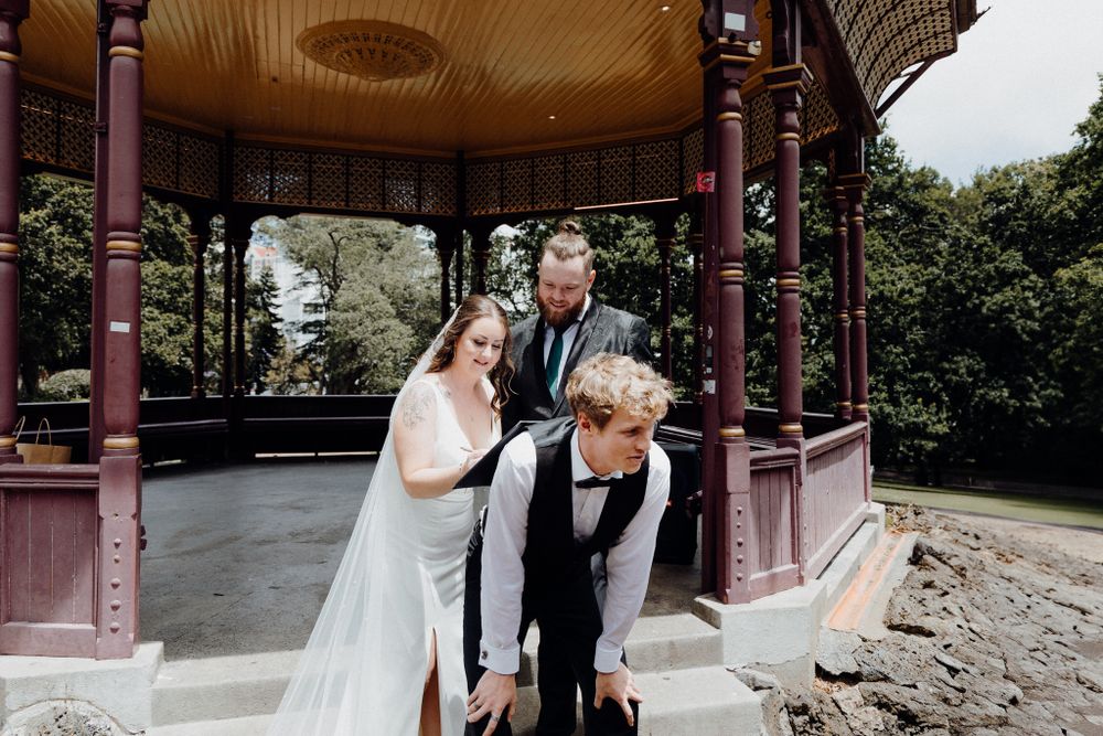 The bride and groom signs the marriage contract in a playful way, captured by Apertured Media Auckland Wedding Photographer.