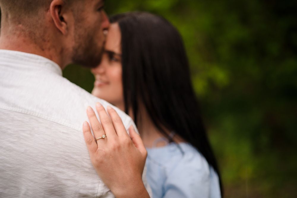 A tender moment captured between a couple in a natural outdoor setting.