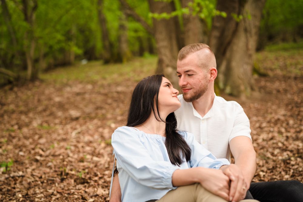 Intimate forest engagement photos with soft natural lighting filtering through trees.