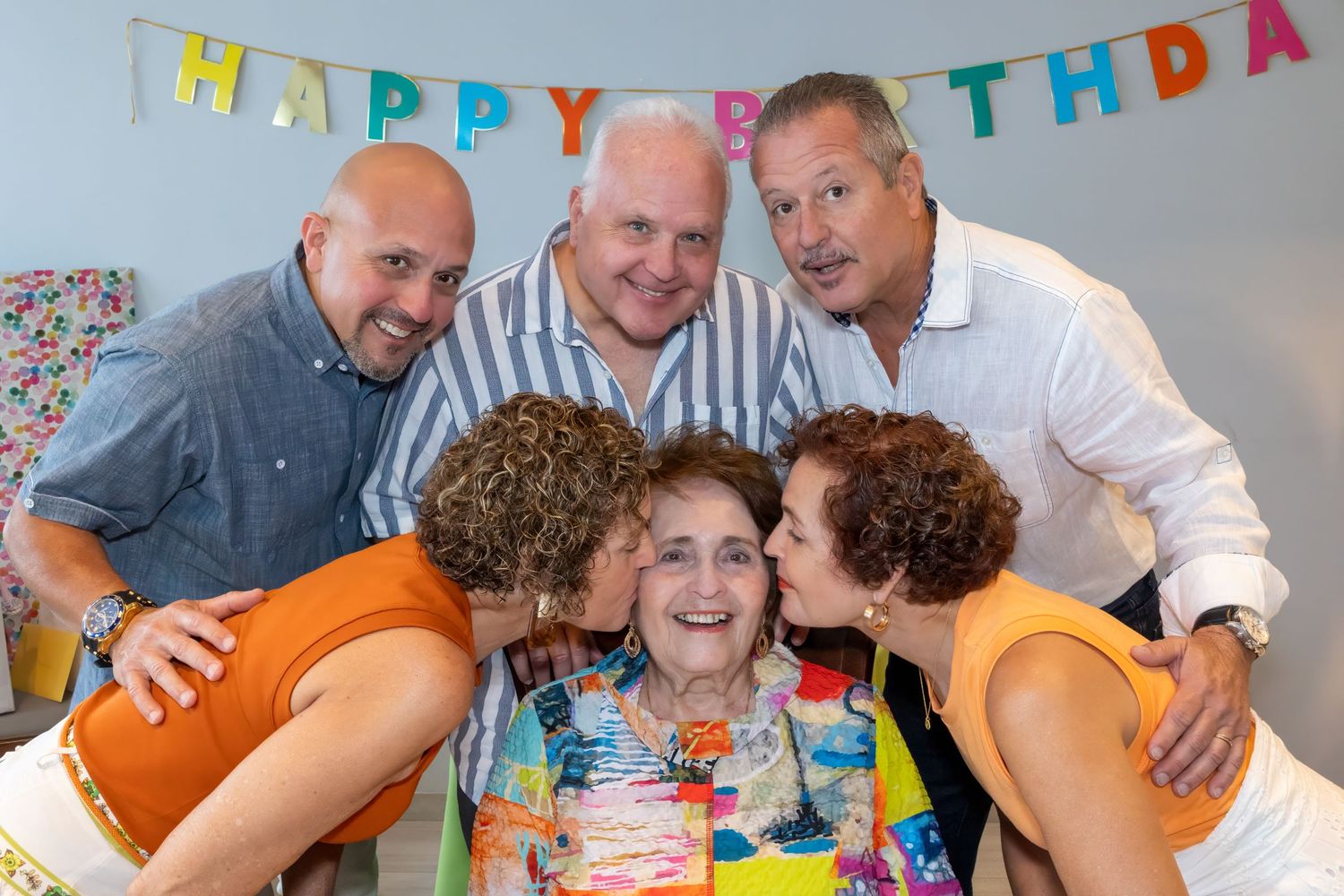 Family celebration photo with birthday banner showing joyful group moment.