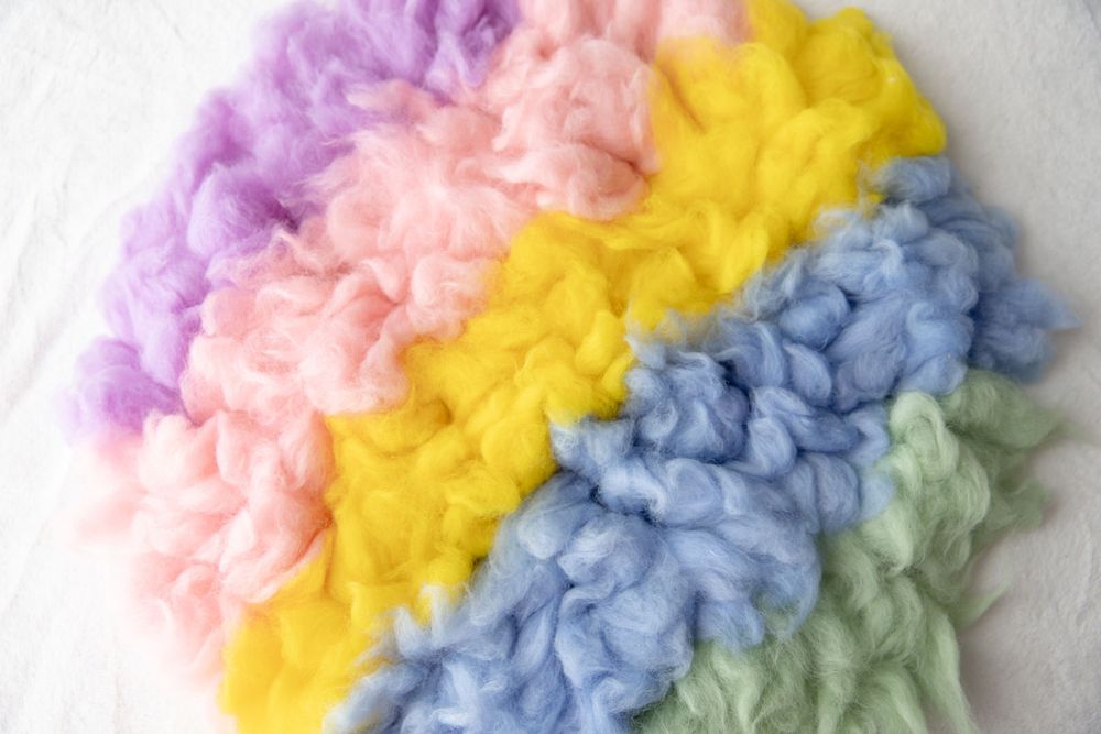 Colorful pastel rainbow wool roving fiber in purple pink yellow blue green.