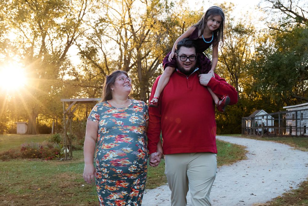 Happy family sharing joyful moments together on a sunlit path during golden hour.