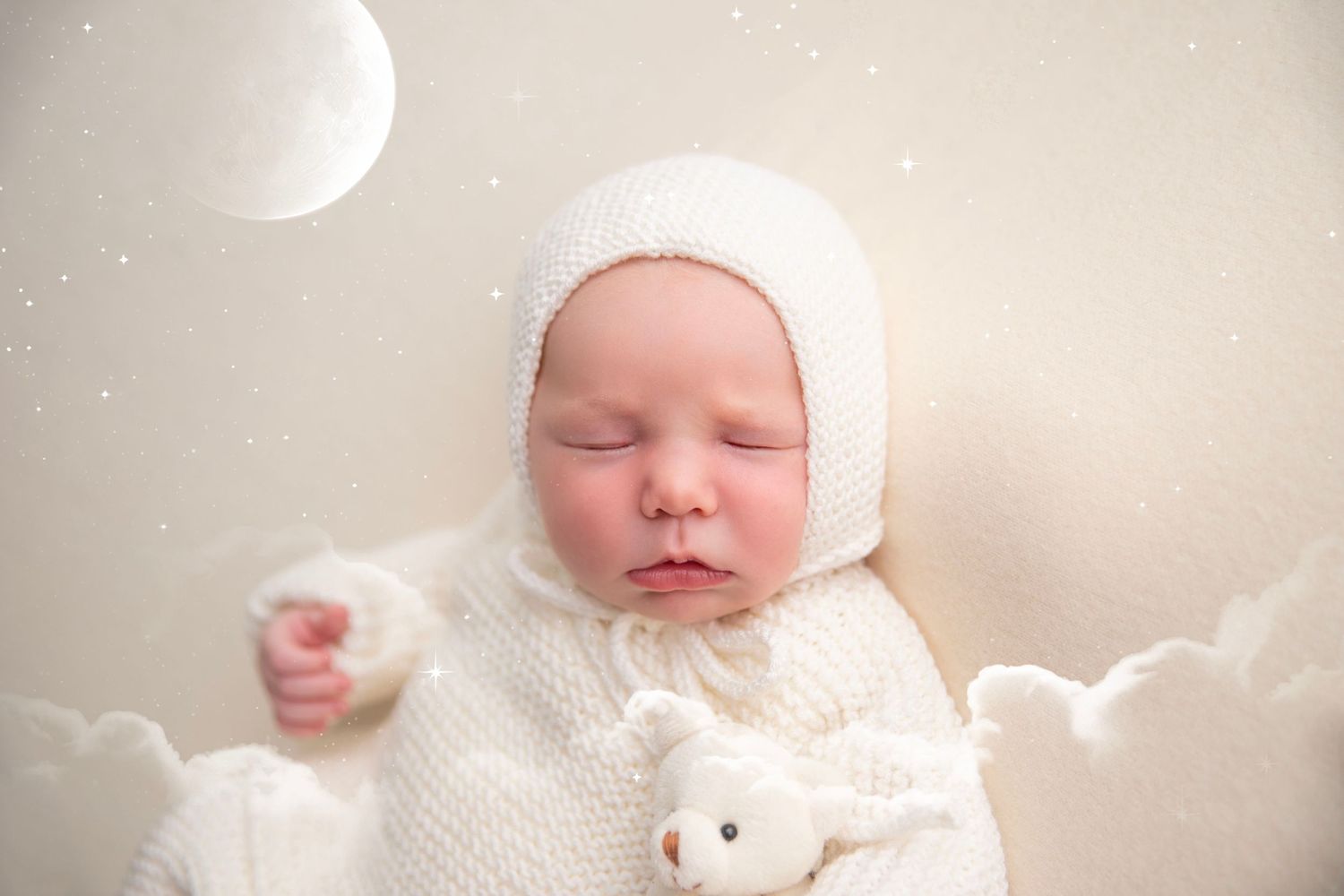 Peaceful newborn baby in white knit outfit and bonnet sleeping with teddy bear in dreamy moon scene.