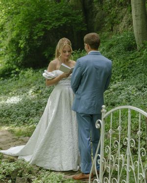 A romantic wedding exchange captured against lush green foliage.