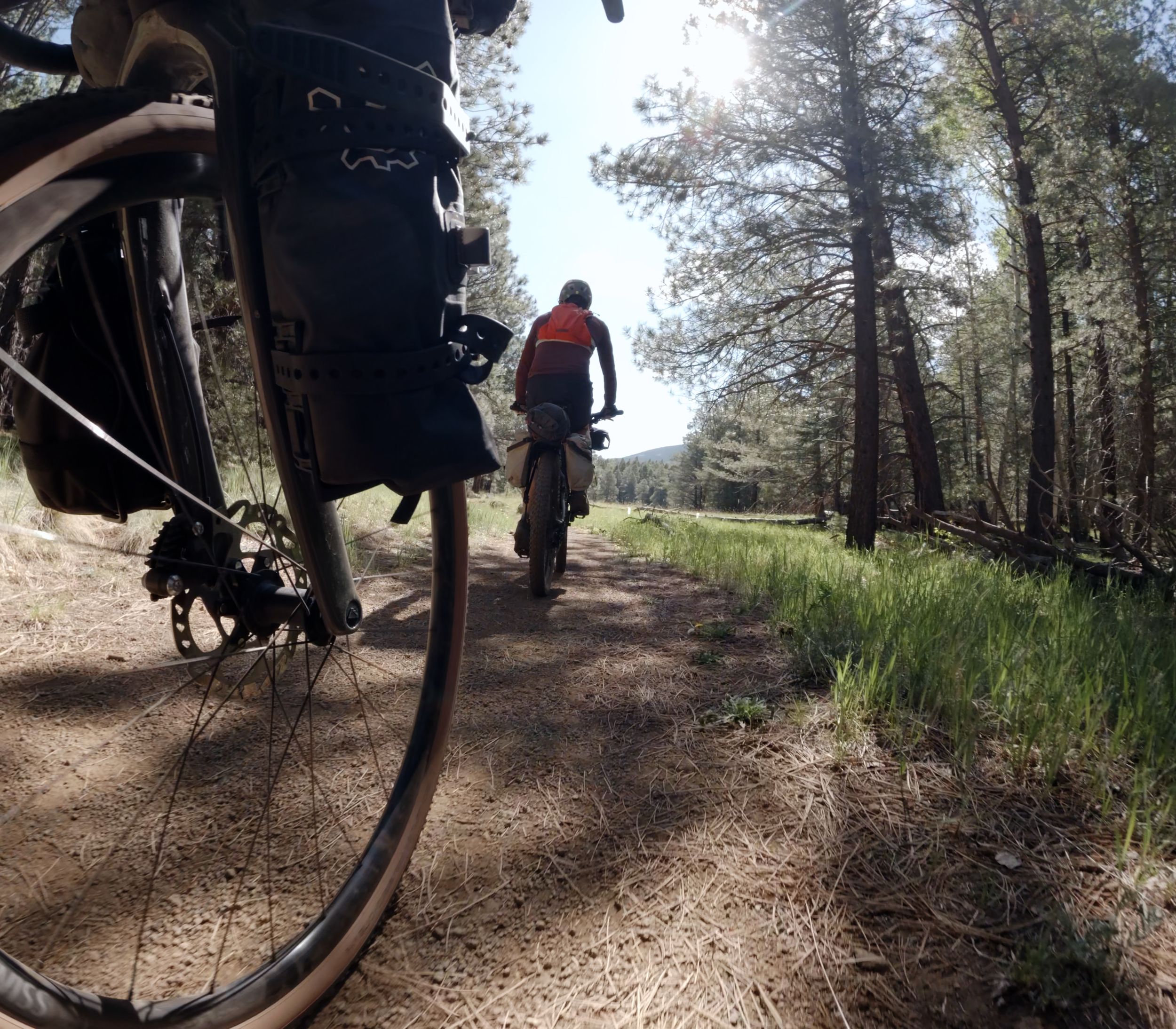 A low angle photo from the GoPro showing Sean and Kris riding in the woods.