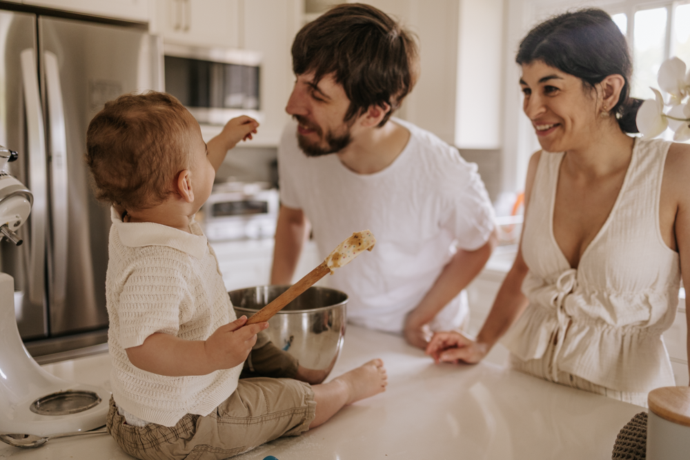 YONGE PARENTS MAKING COOKIES AT THE WHITE KITCHEN WITH THEIR 18 MONTH YEAR OLD BABY AND TRYING TO TASTE THE DOUGH