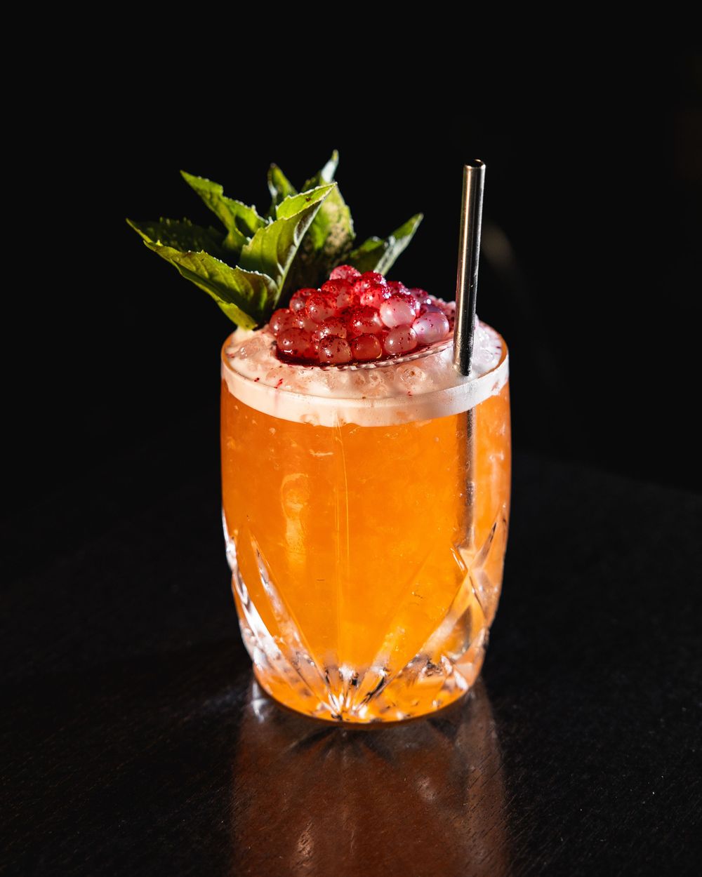 A sequence of orange cocktails with crushed ice and garnishes shown in progressive stages of assembly against a dark background.