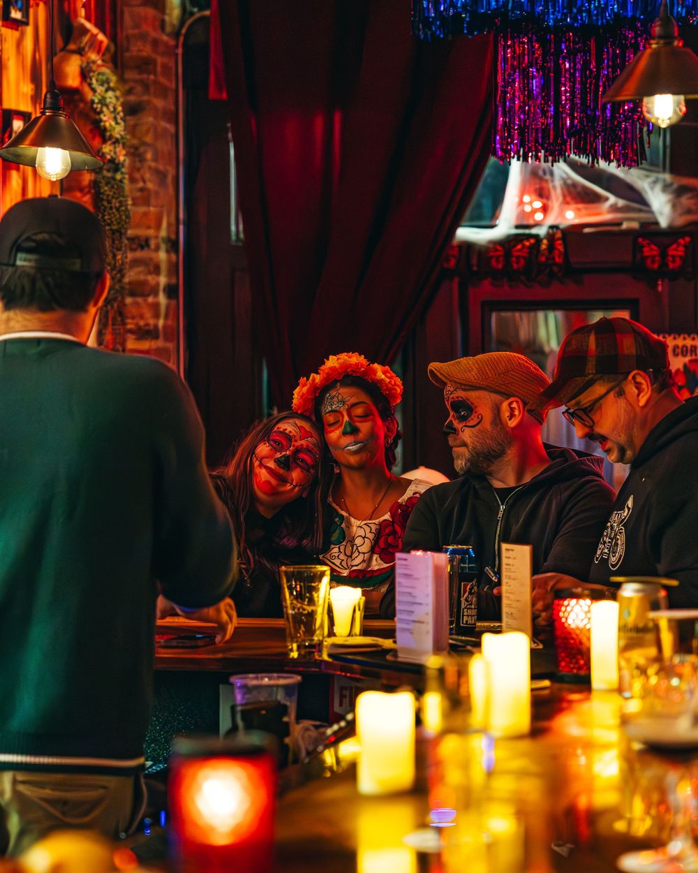 Candlelit bar scene with warm glowing ambiance and silhouettes of patrons in a dimly lit setting.