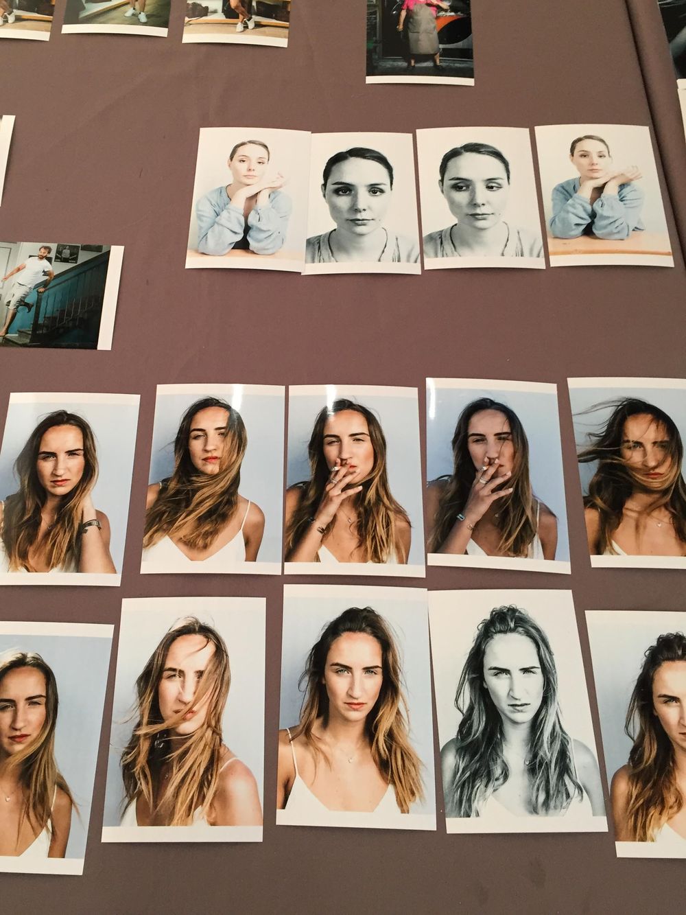 A collection of portrait photographs arranged in rows on a brown wall showing different poses and artistic expressions.