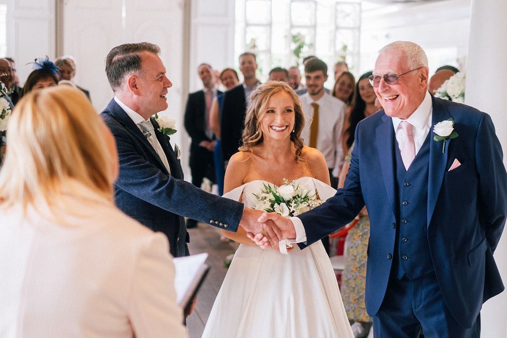 A celebratory moment during a wedding ceremony in a bright indoor venue.