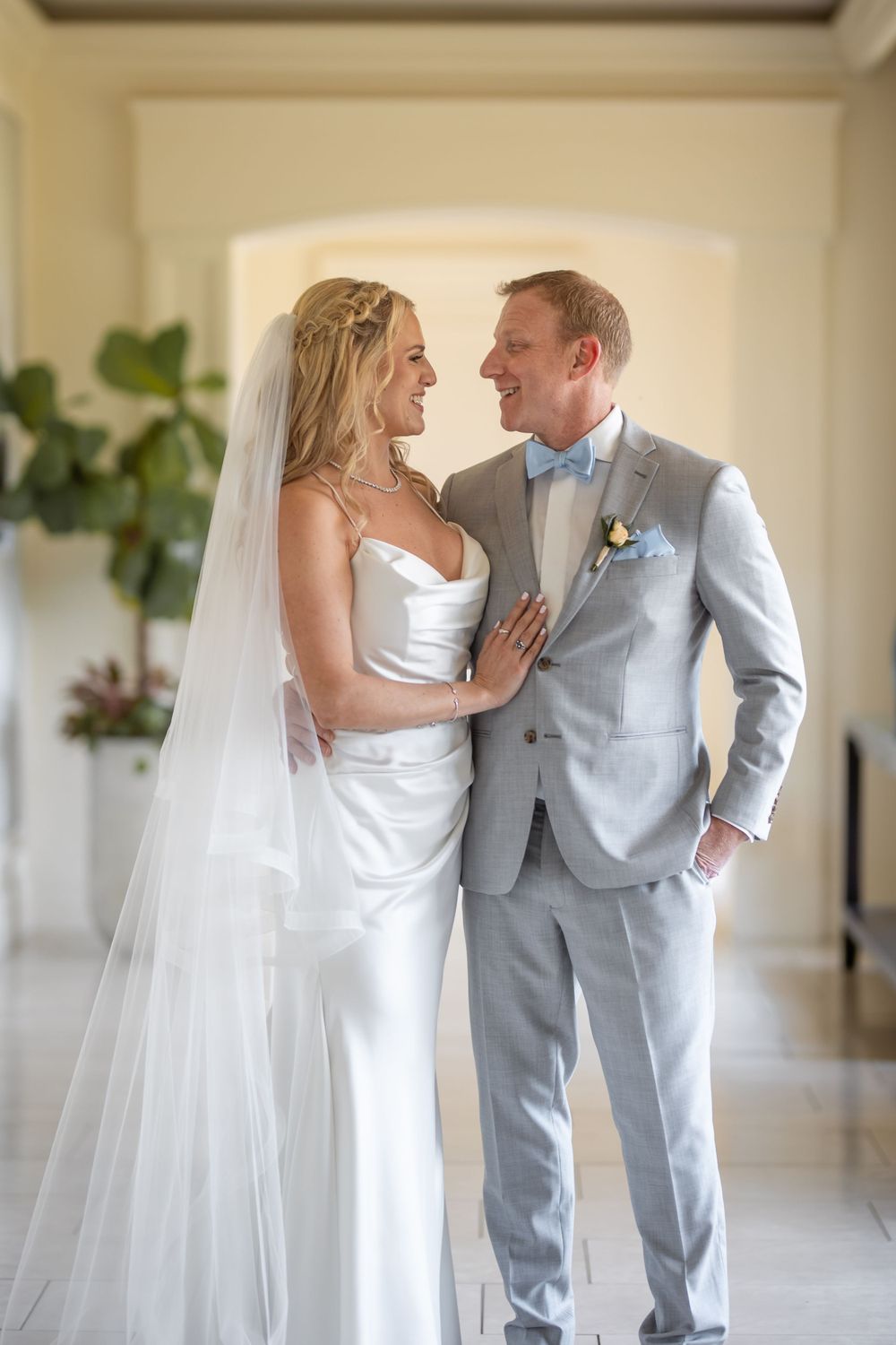 A romantic portrait of the newlyweds sharing a moment in an elegant hallway setting.