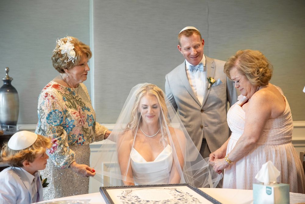 Wedding guests gather around a table during a reception celebration.