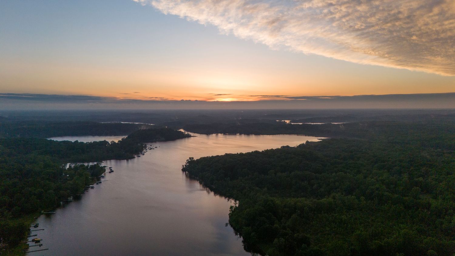 A drone shot of a sunset over a lake