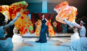 Dance performance with flowing orange fabric creating dramatic movement on stage.