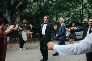 Outdoor celebration with musicians playing drums while guests dance.