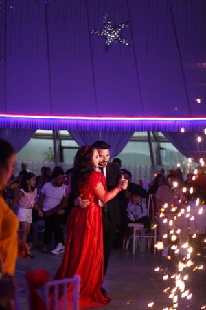 Couple dances under a star decoration with sparklers creating a magical purple-lit atmosphere.