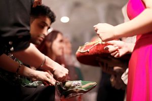 Hands exchanging items during a wedding reception in dim lighting.