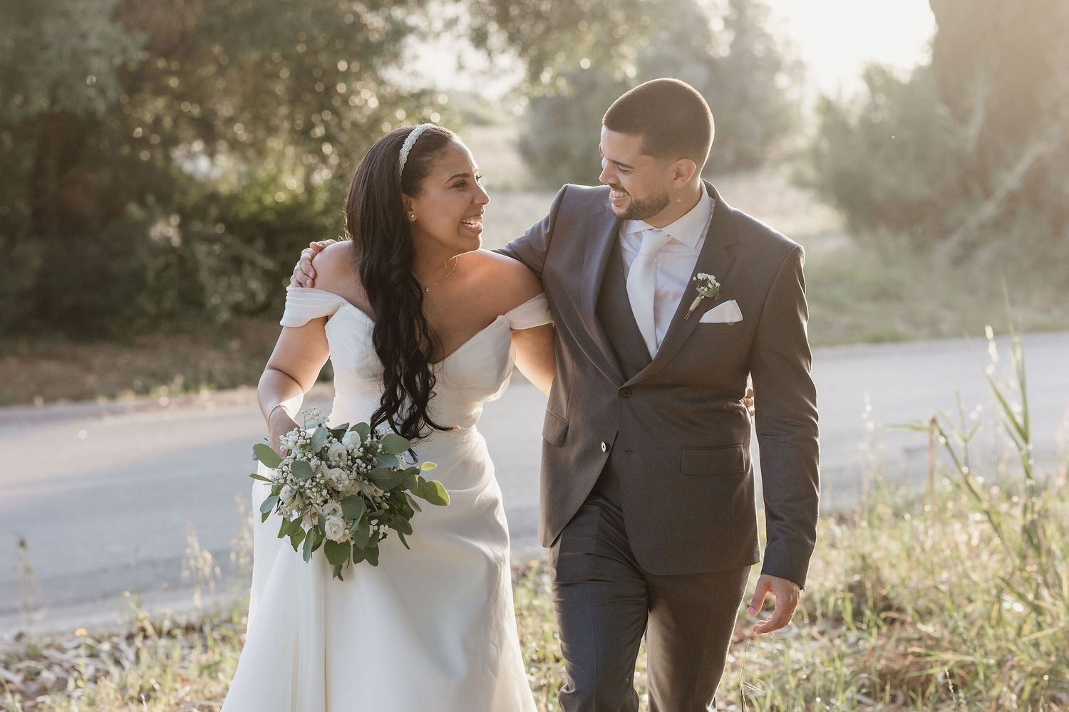Romantic sunset portrait of newlyweds in a vineyard with golden backlight.