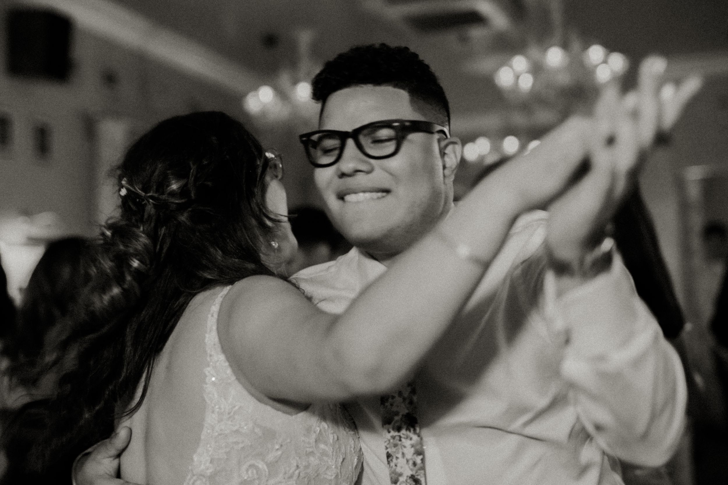 Couple sharing an intimate dance moment in black and white at a formal event.
