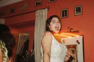 Dancing guest celebrates with joy at a wedding reception in a coral-colored room.