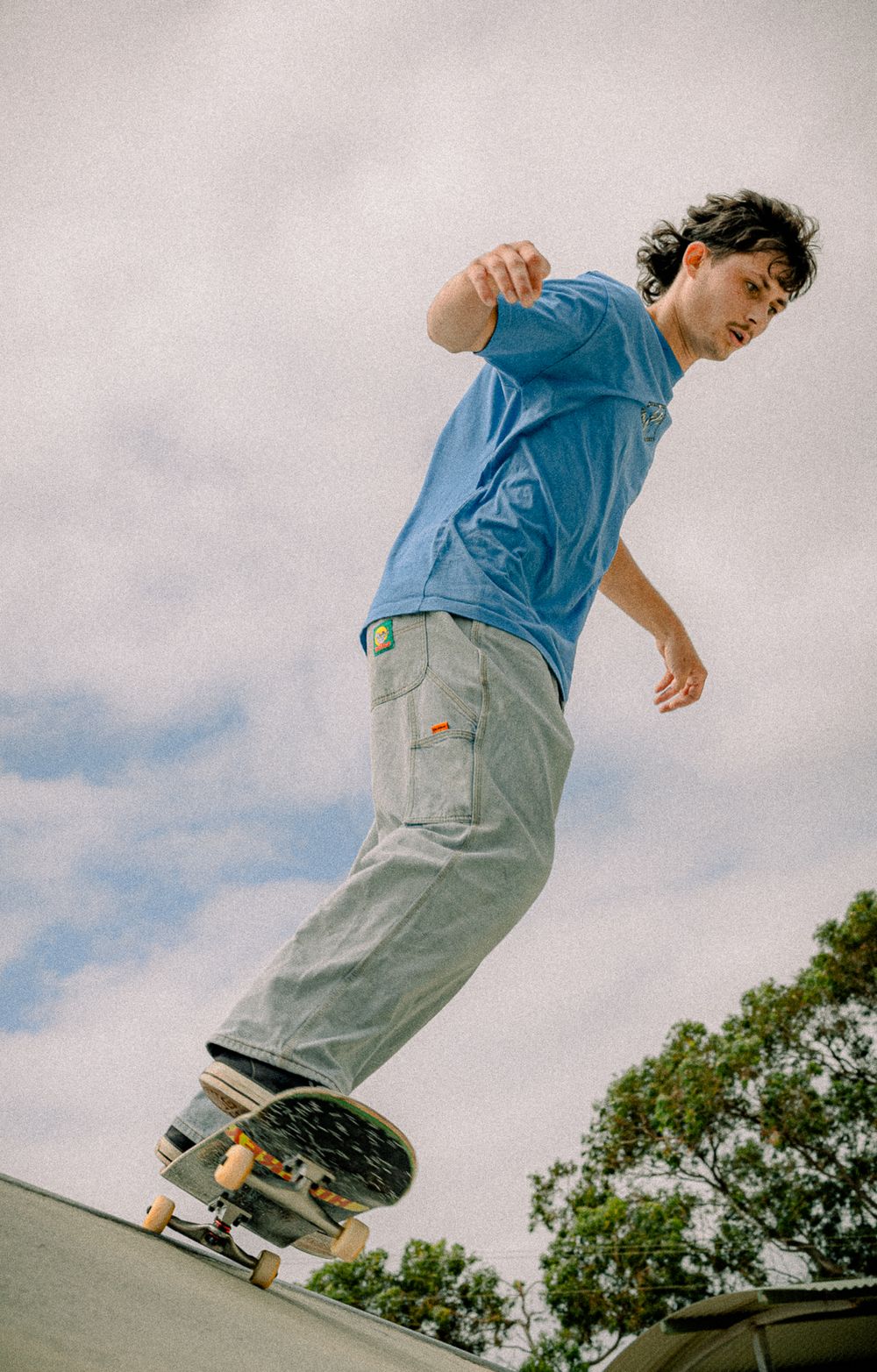 Action sequence of skateboarding moves on concrete ramp with cloudy backdrop.