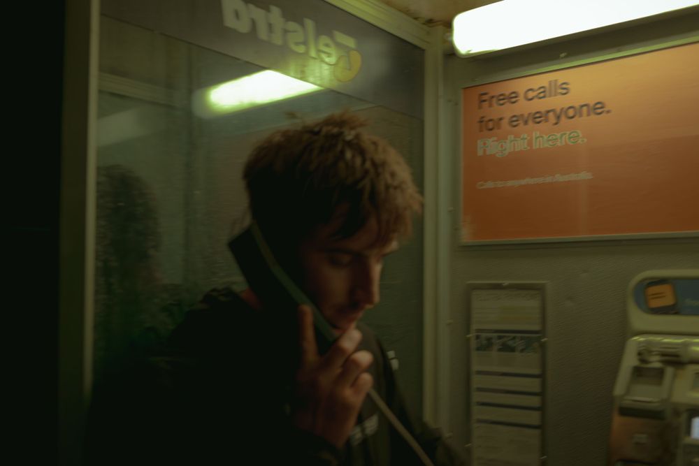 Interior of a phone booth with orange signage visible in the background.