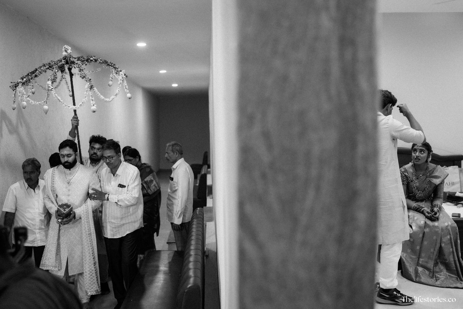 Black and white photo showing people gathered at an indoor event space with ambient lighting.