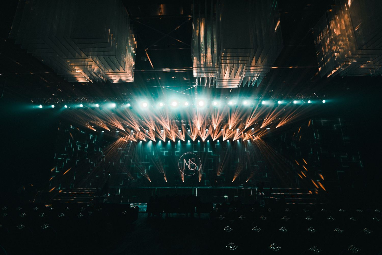 Concert stage illuminated with dramatic blue lights and beams creating a stunning atmospheric effect.
