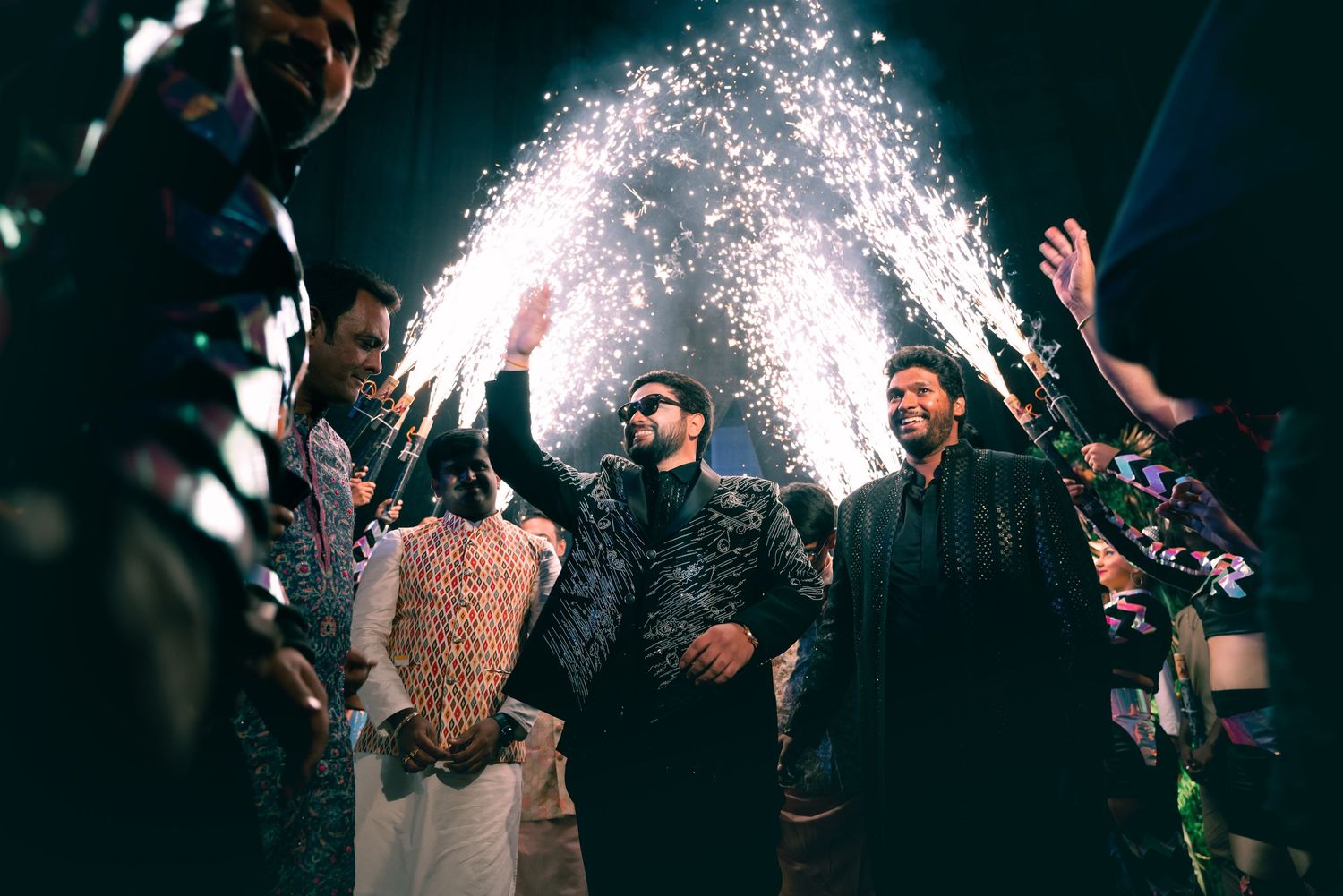 People celebrating at a nighttime party with sparkling pyrotechnic effects creating an energetic atmosphere.