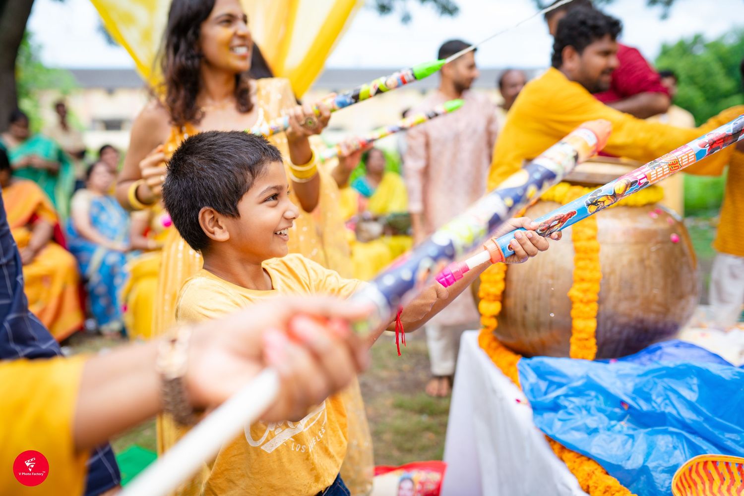Guests celebrating with colorful decorations at a traditional Indian Haldi ceremony in yellow attire.