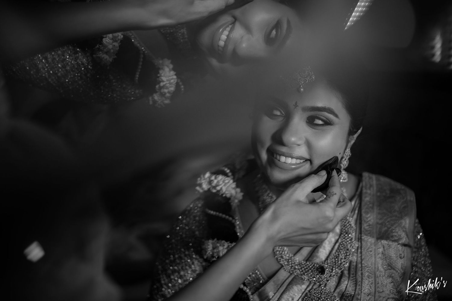 A monochrome portrait captures a tender moment with traditional jewelry and attire.