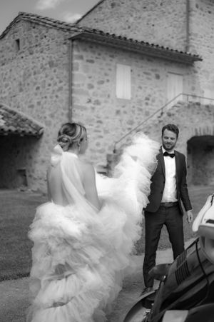 A playful wedding photoshoot sequence near a rustic stone building with flowing white dress movement.