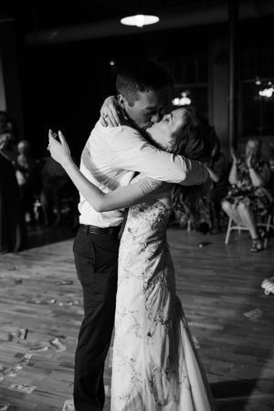 A romantic black and white photo of a couple dancing closely at their wedding reception.