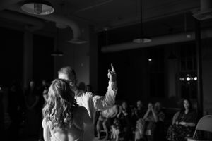 Black and white dance floor photo showing celebration at a wedding reception.