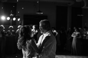 An intimate black and white photo of a couple dancing together at their wedding reception.