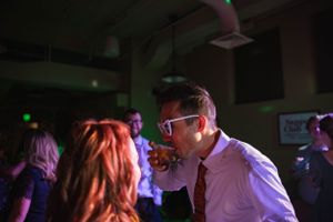 Colorful nightclub scene with party lights and dancing couples.