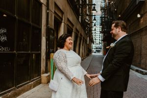 A couple sharing a tender moment in an urban alleyway during their wedding photoshoot.