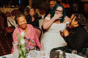 A candid moment of laughter shared between friends at a dinner table in a restaurant setting.
