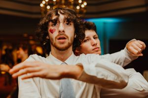 Two people dancing together under warm lighting at an indoor event.