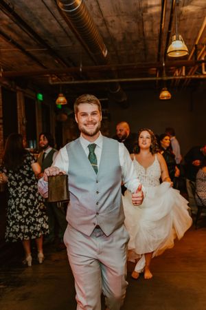 Wedding party celebrating in an industrial venue with exposed brick walls and pendant lighting.