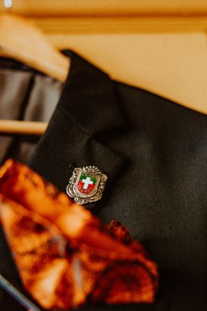 Close-up shot of a Swiss cross emblem pin against a black fabric background.