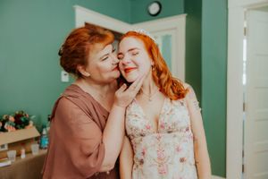 Two people sharing an affectionate moment in a room with mint green walls.