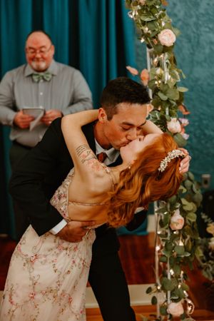 A romantic dance moment captured at a wedding with floral decor and turquoise backdrop.