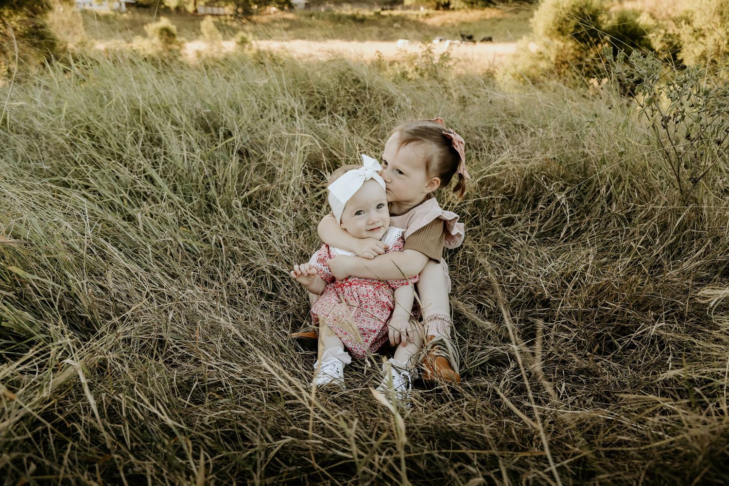 Two sisters having a cuddle and kiss