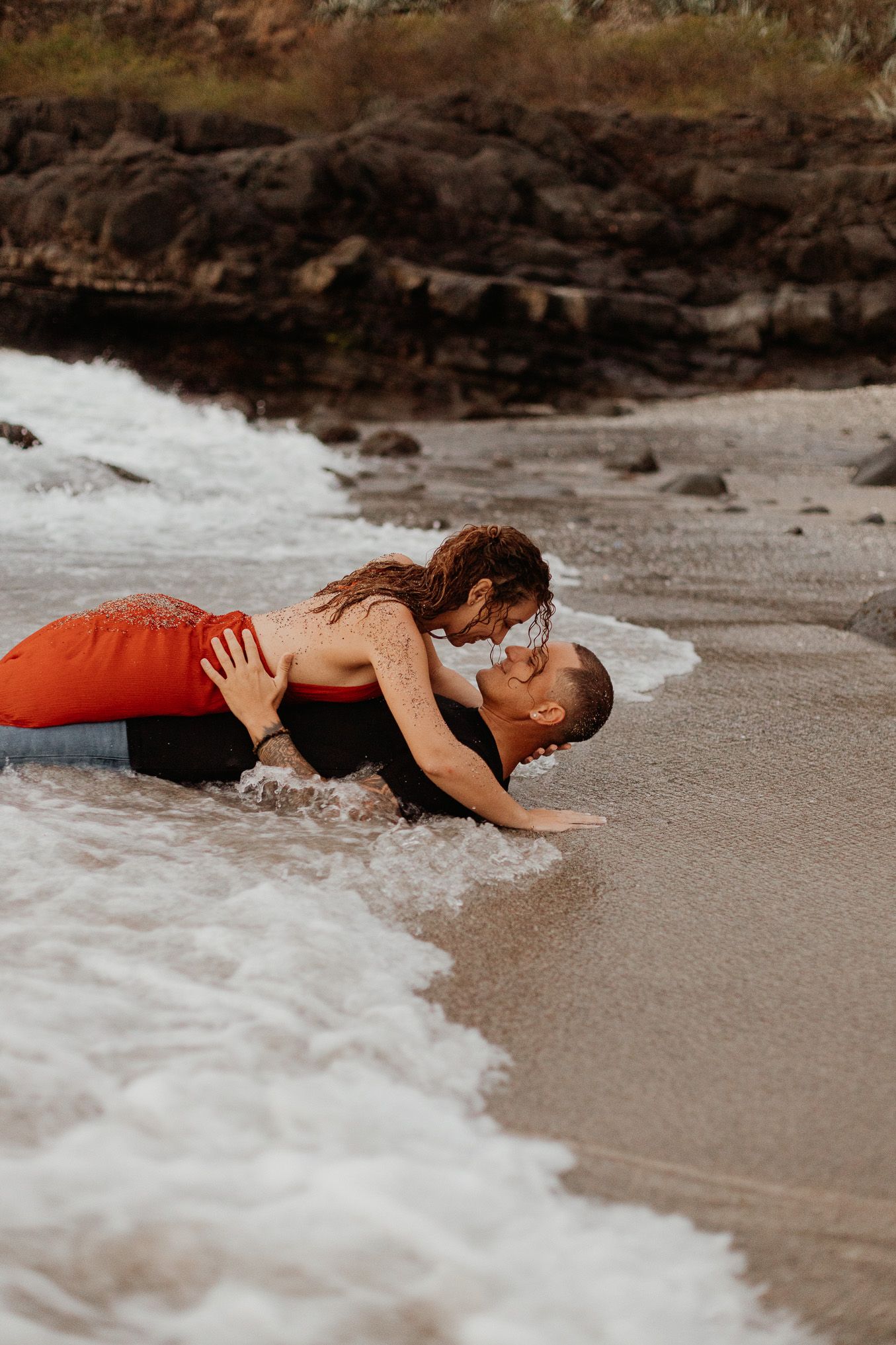 une vague surprend un couple sur une plage de Vendée