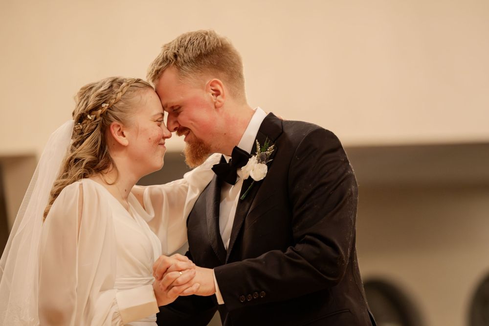 Bride and groom share an intimate moment smiling at each other during their wedding ceremony.