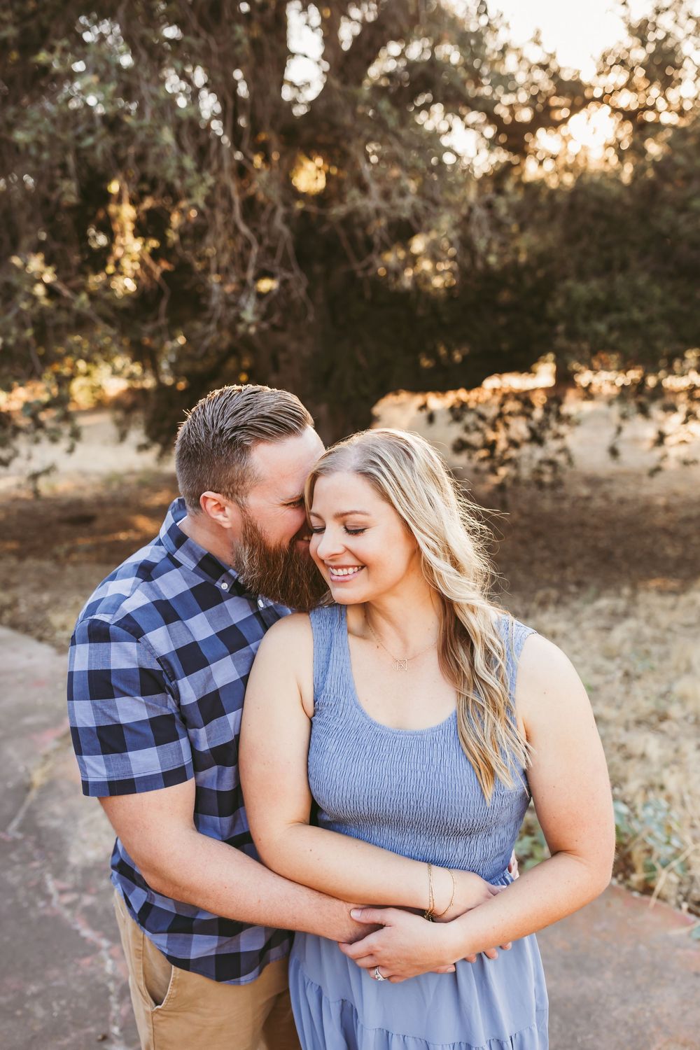 A couple embraces outdoors during their family photos at a park in yucaipa ca with heidi grace photography.
