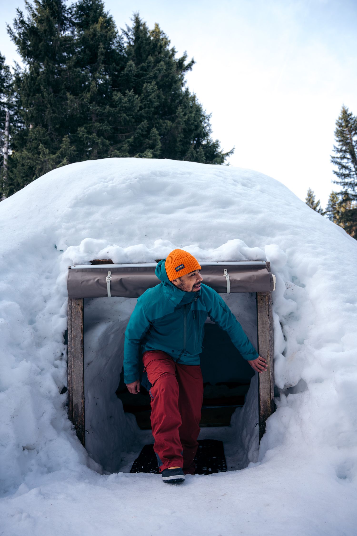 Photo d'un homme sortant d'un igloo dans un  village d'igloo à Annecy