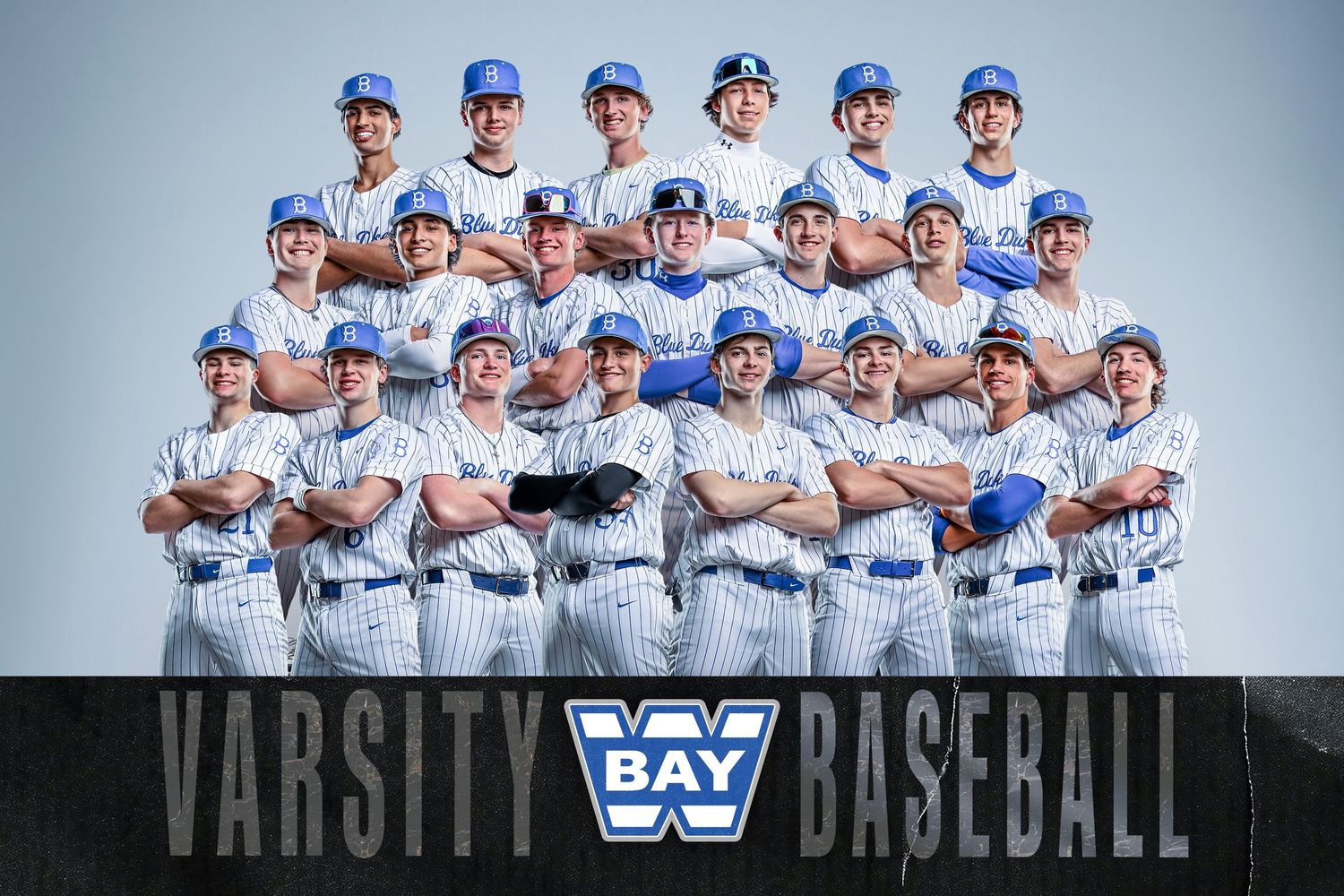Bay varsity baseball team poses in blue and white uniforms for official group photo with team logo banner.
